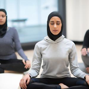 3 Muslim women doing yoga