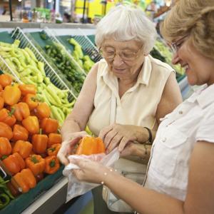 Volunteer helping elderly women with her fruit and veg shopping