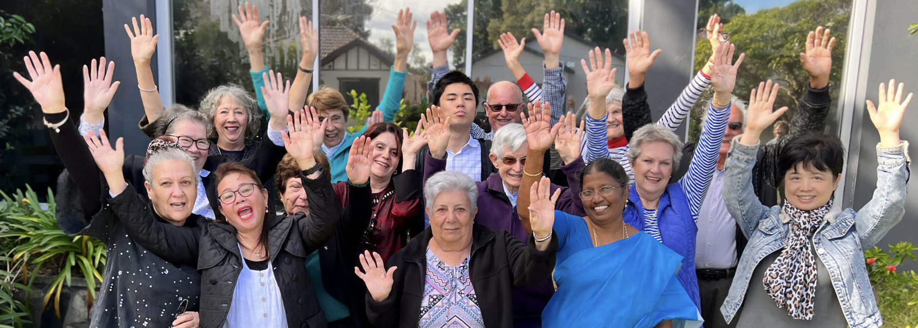 Group photo of 4Cs volunteers smiling with their hands raised in celebration