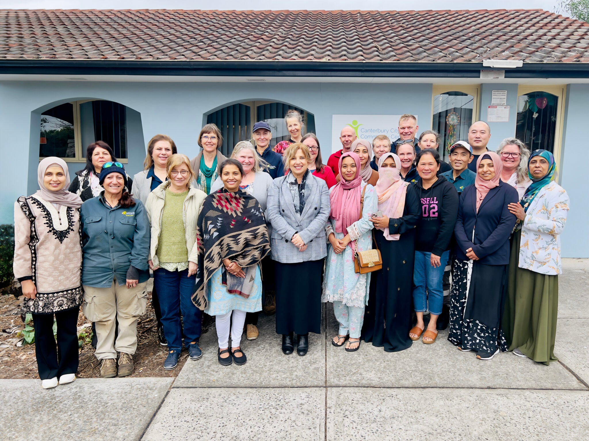 Group photo of 4Cs staff smiling in front of the 4Cs Community Centre.