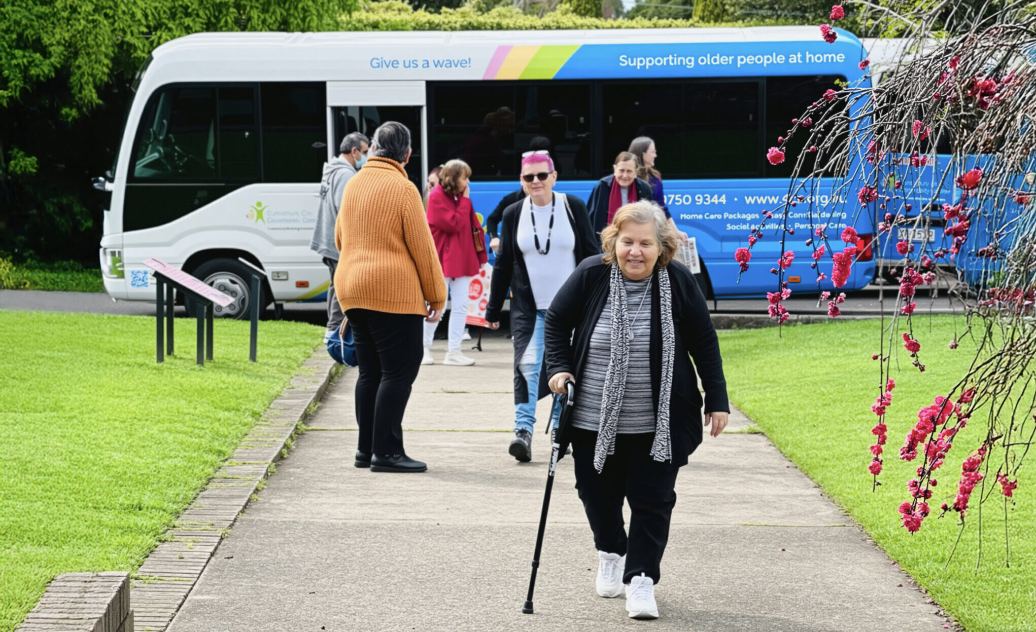 Social group clients on an outing with the 4Cs comminity bus in the background